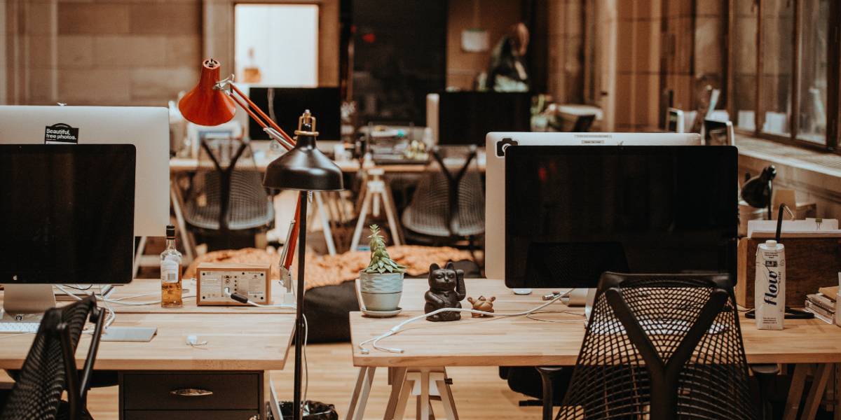 Blogpost_DSB Symbolbild: Ein modernes Büro mit Bildschirmen auf Schreibtischen