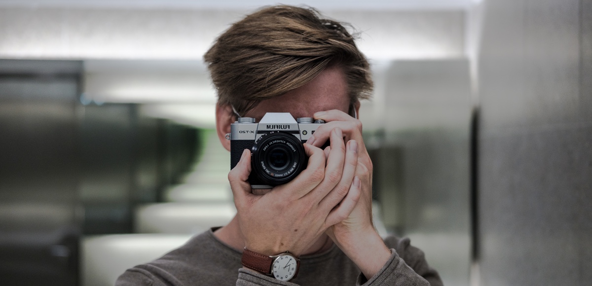 Symbolbild: ein Mann fotografiert sich selbst in einem Spiegel