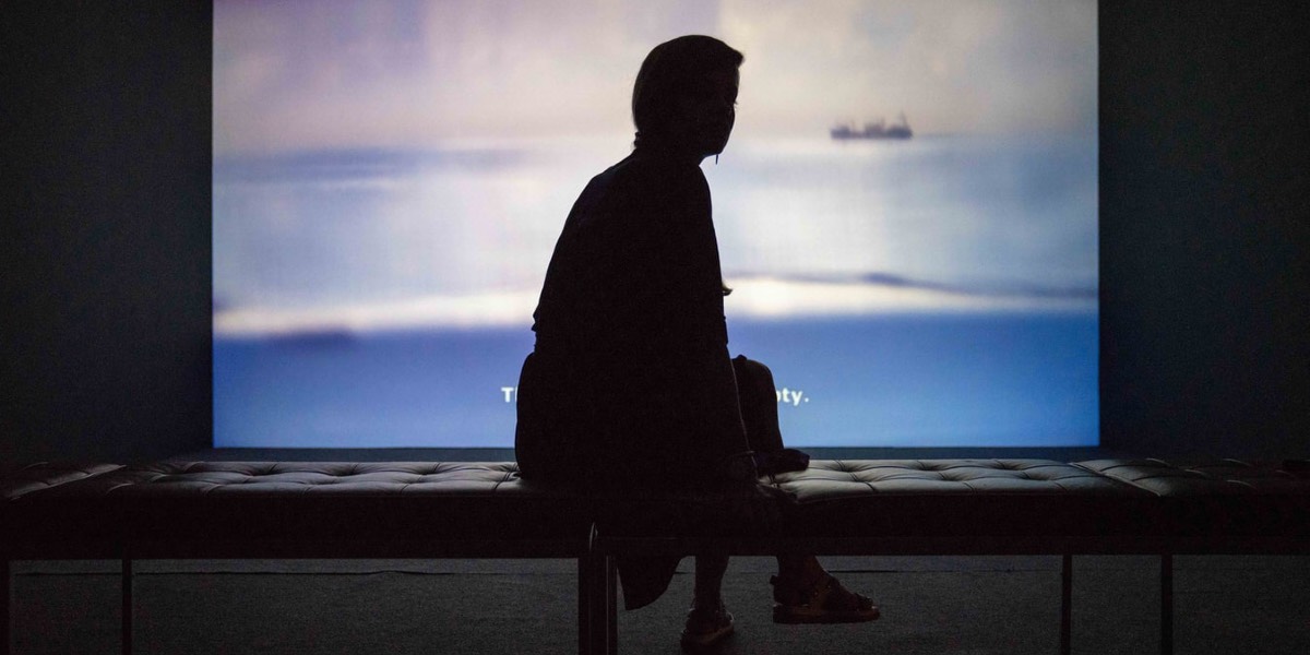 dynamic_ip Symbolbild: Eine Frau sitzt vor einer Hellen Leinwand auf einer Bank