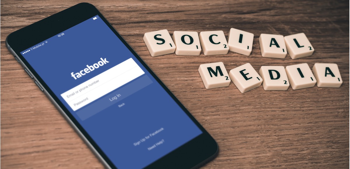 Symbolbild: Der Facebook Login Screen mit Social Media in Scrabble Buchstaben daneben