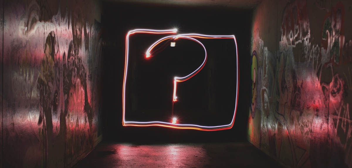 Symbolbild: Ein mit Lichtmalerei erstelltes Fragezeichen in einem dunklen Gang
