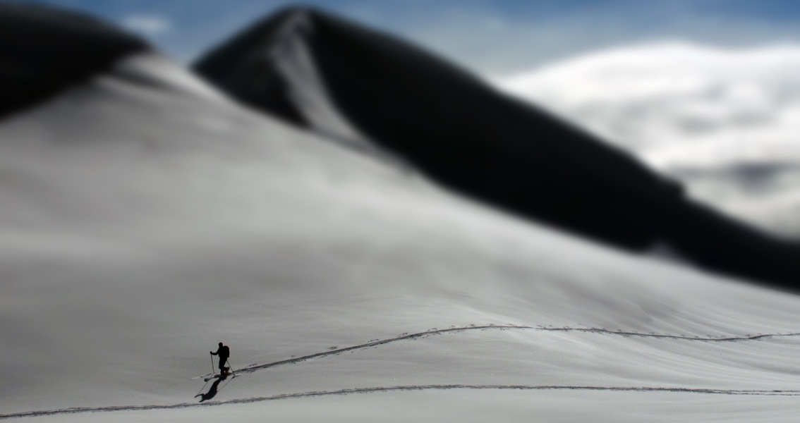 website_tracking Symbolbild: eine Person wandert auf einem schneebedeckten Berg